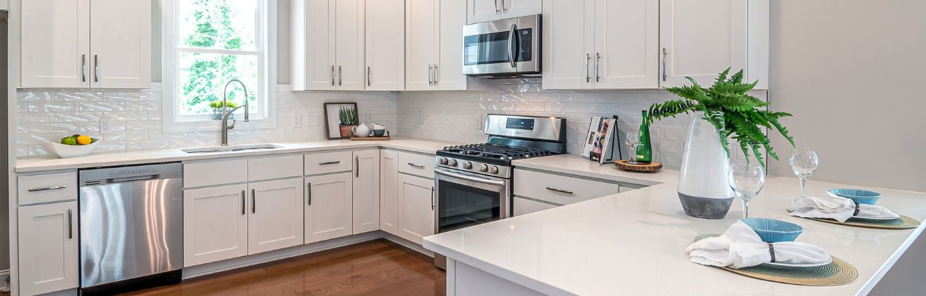 A wide view of a modern kitchen with stainless steel appliances.