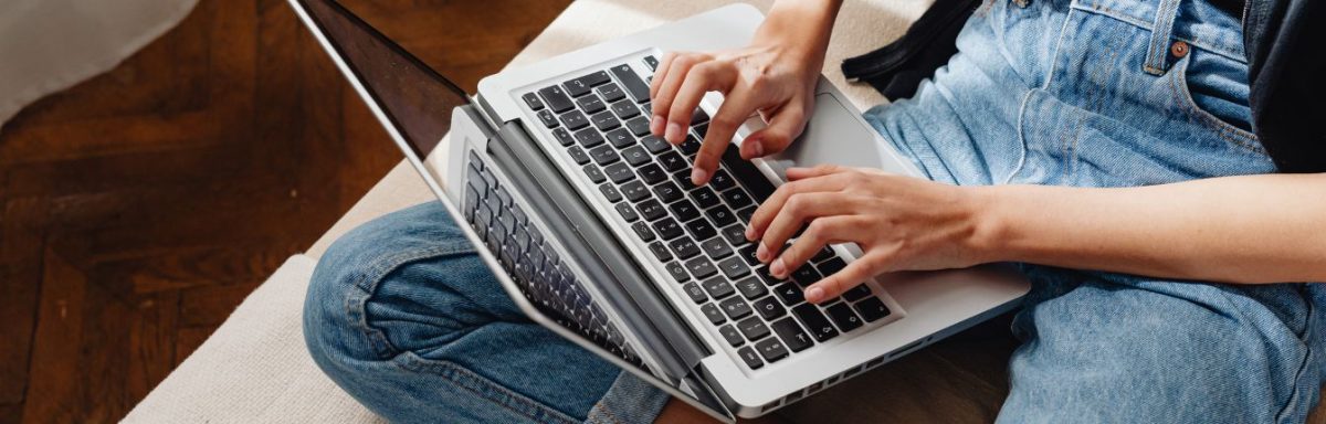 A woman typing on a laptop. It's zoomed in on her hands on the keyboard.