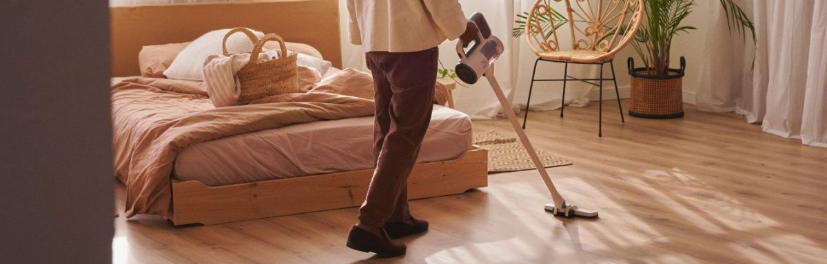 A person vacuuming their bedroom.