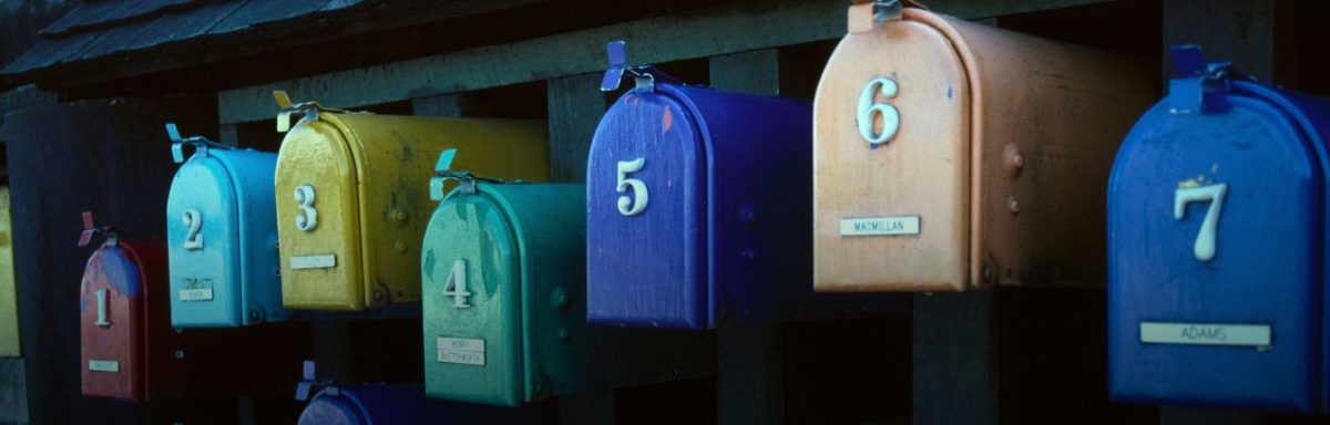 Different colored mailboxes mounted outside.