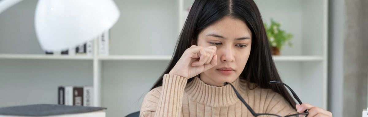 A woman rubbing her eyes.